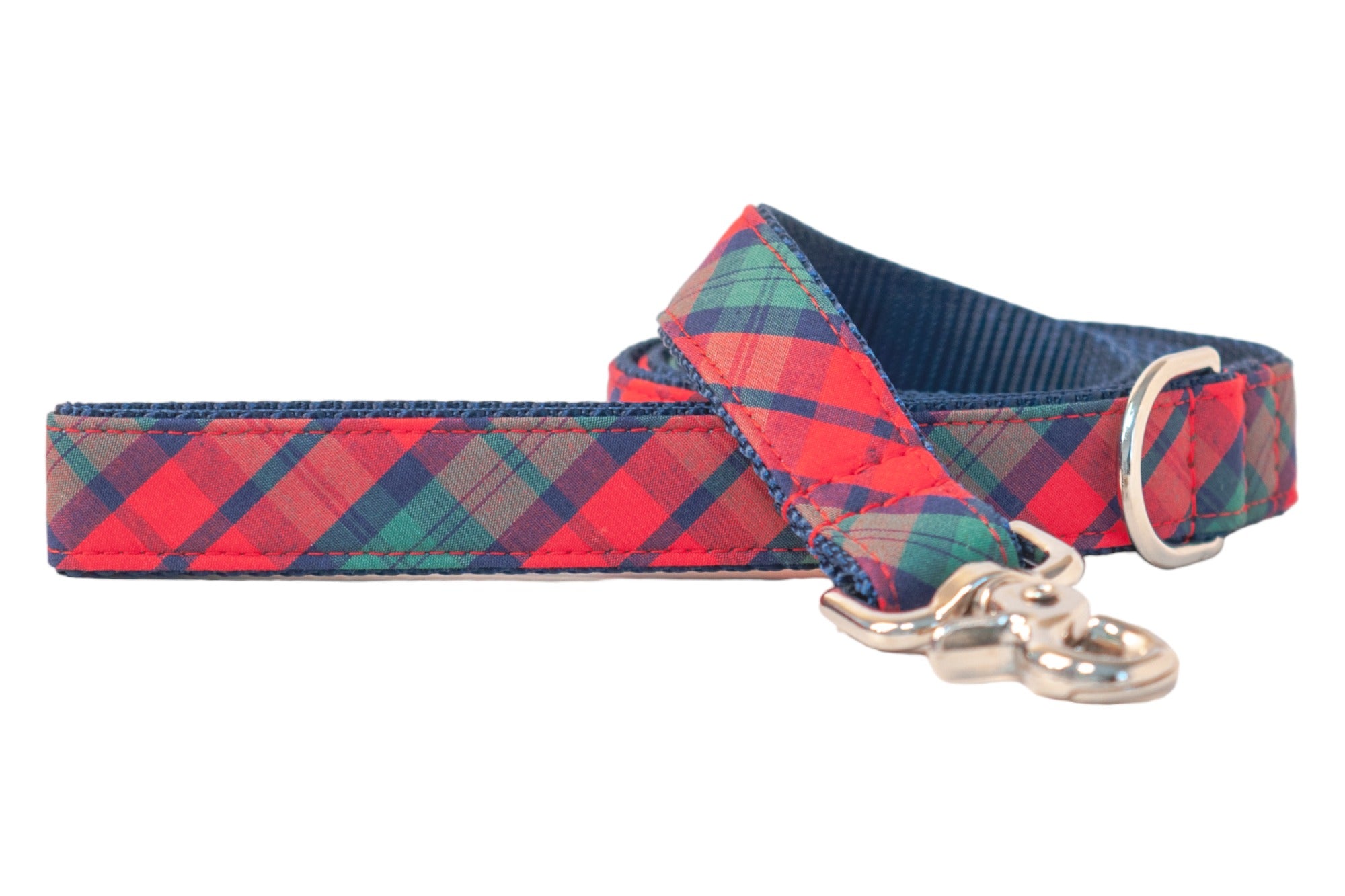 A vibrant dog leash with a bold red plaid design. It features double-stitched edges for durability, a nylon inner lining for better handling, and metal hardware, including a sturdy clasp and a rounded D-ring. 