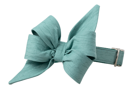 Textured teal dog collar with a large, structured  girls belle bow in matching fabric, designed with soft wave-like patterns and pointed tails. 