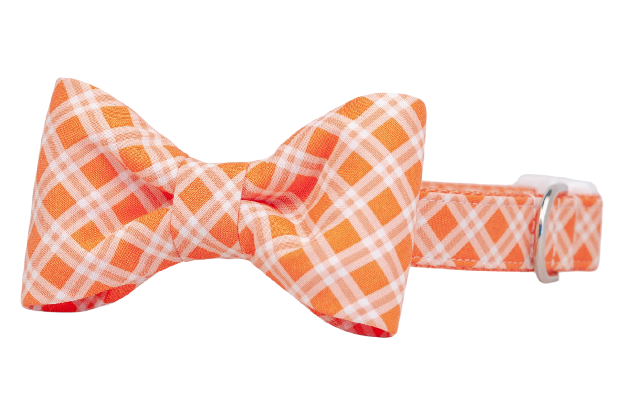 Dog collar featuring a matching orange and white plaid bow tie, secured with a silver D-ring for leash attachment and white plastic buckle.