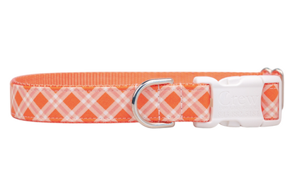 Plaid-patterned collar in shades of orange and white, designed for dogs with a white plastic buckle and a silver D-ring for leash attachment.