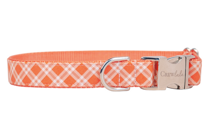 Plaid-patterned collar in shades of orange and white, designed for dogs with a silver metal buckle and a silver D-ring for leash attachment.
