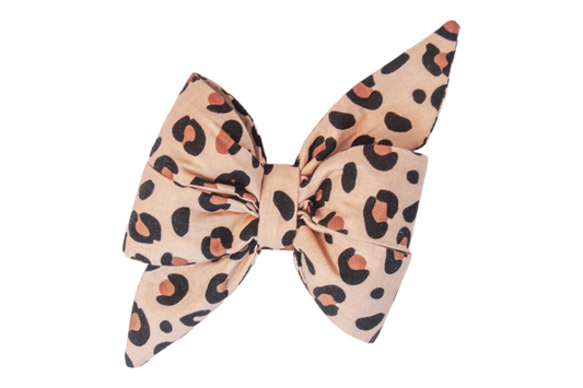 Chic and sassy belle bow for dogs, crafted from soft tan fabric and covered in a bold, leopard print—perfect for pups with fierce fashion sense and runway-ready energy.