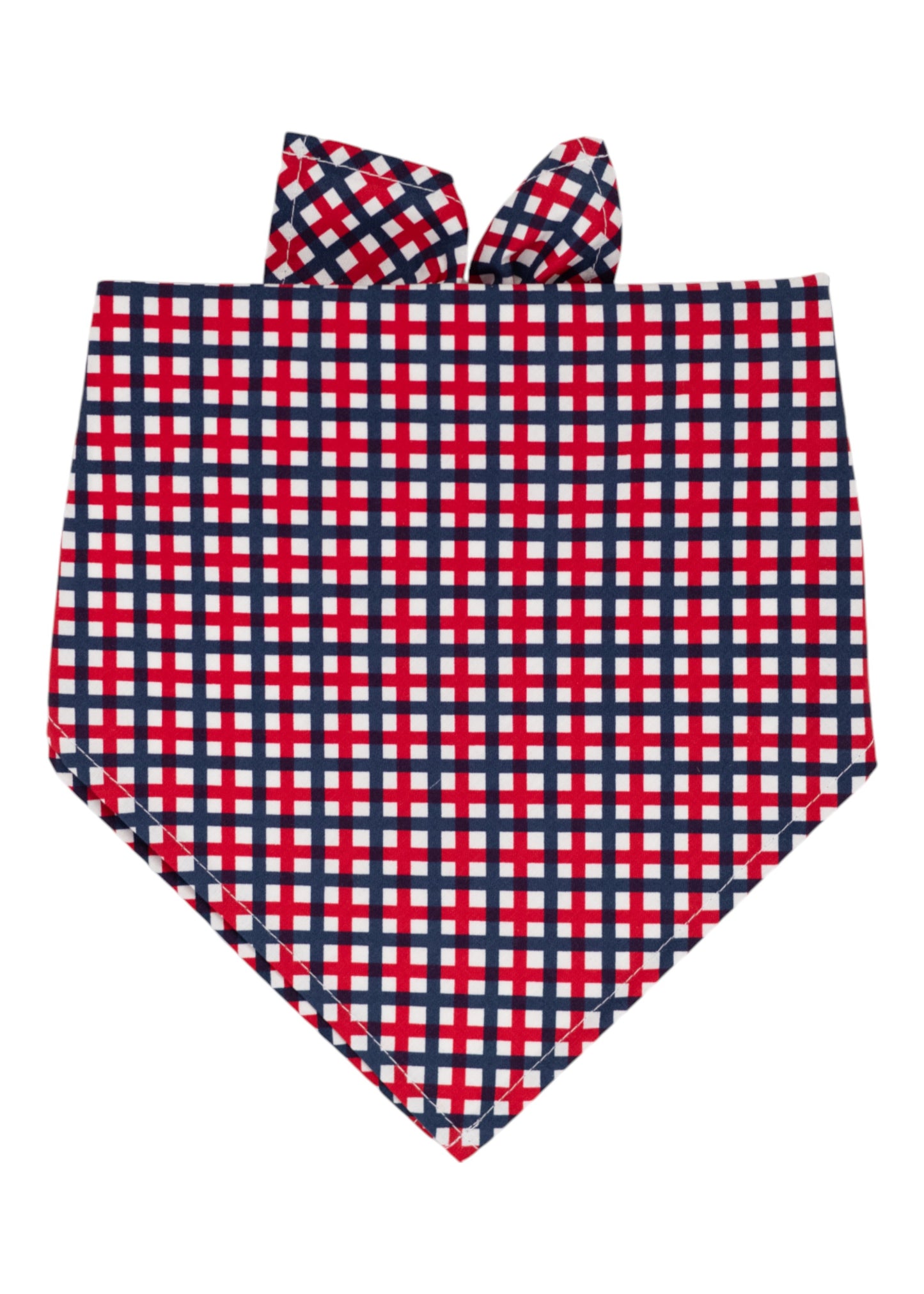 A patriotic themed dog bandana with a red, white, and navy blue plaid pattern, folded into a triangular shape with tie-up ends at the top. 