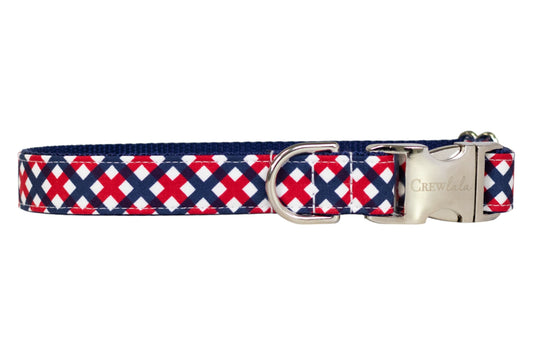 Close-up of a dog collar with a bold red, white, and navy blue patriotic plaid design, complete with a silver metal D-ring and buckle.
