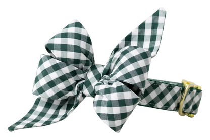 Green checkered dog collar with a large feminine belle bow, combining a playful silhouette with classic plaid style.