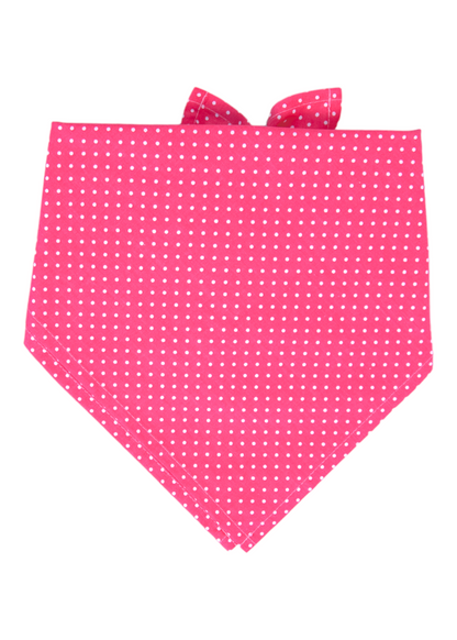 Bright pink dog bandana featuring an all-over white polka dot pattern and a tie-back design with pointed ends.