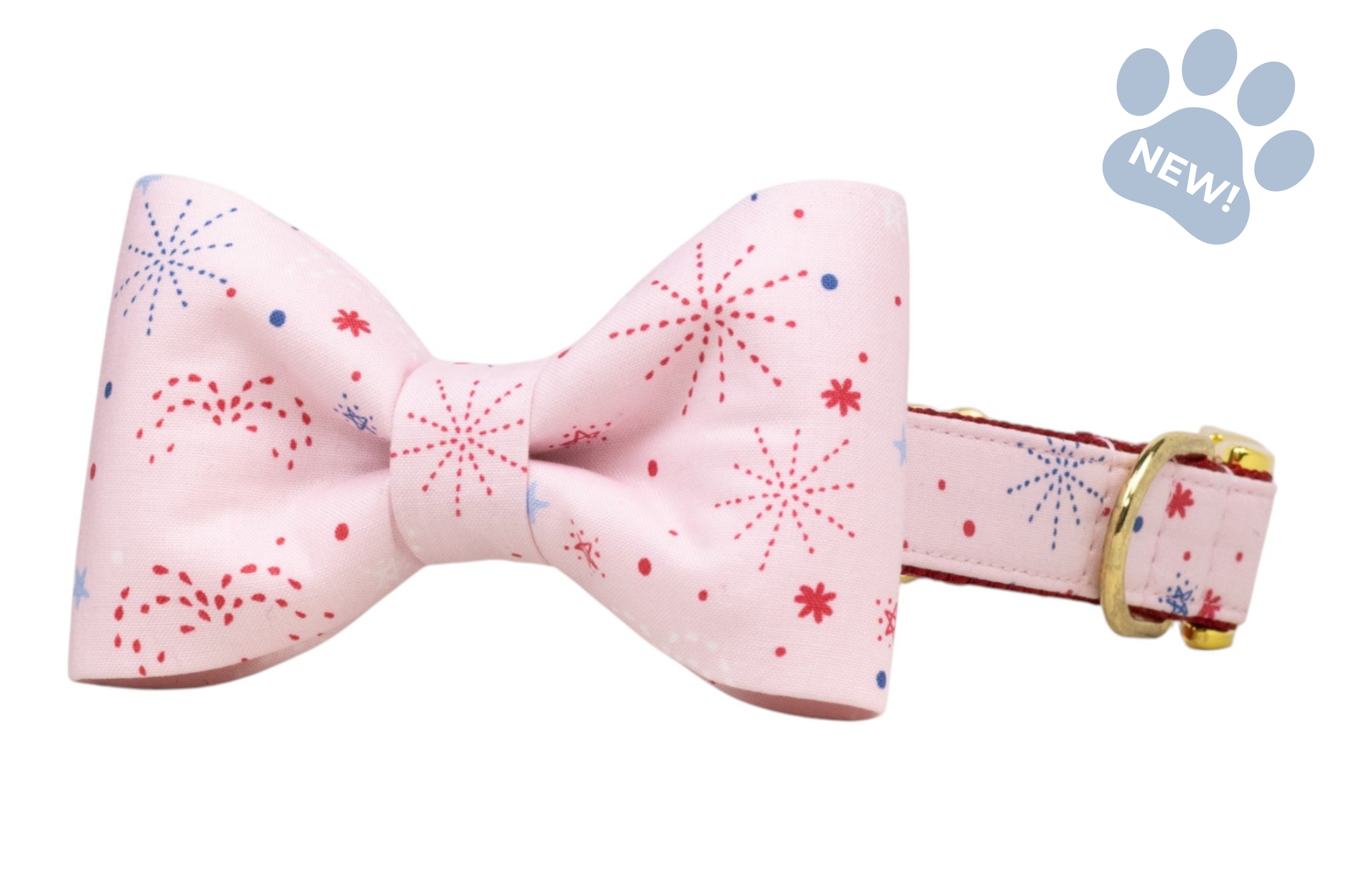 Light pink bow tie dog collar with red and blue firework patterns and a gold buckle, displayed on a white background.