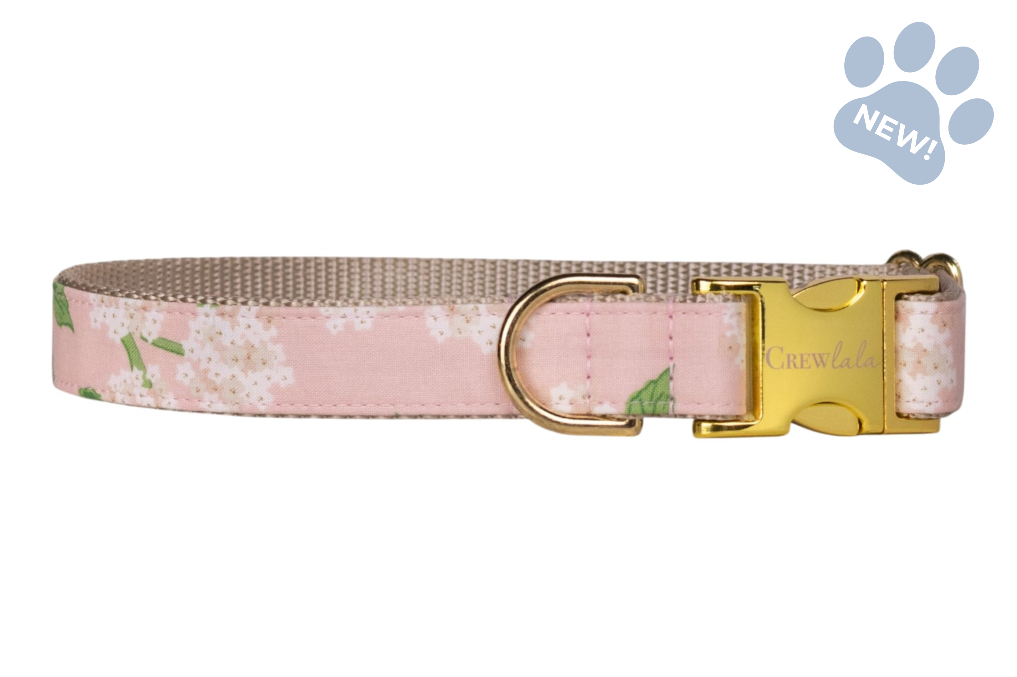 Adjustable dog collar featuring a blush pink hydrangea print with white flower clusters and green leaves, accented by beige webbing and gold-tone hardware.
