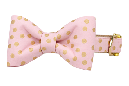 Classic dog collar featuring a Pink Party Dot fabric bow tie, a light pink fabric with scattered metallic gold dots, attached to a matching Pink Party Dot collar with a nylon inner lining and gleaming gold hardware, including a D-ring and buckle.