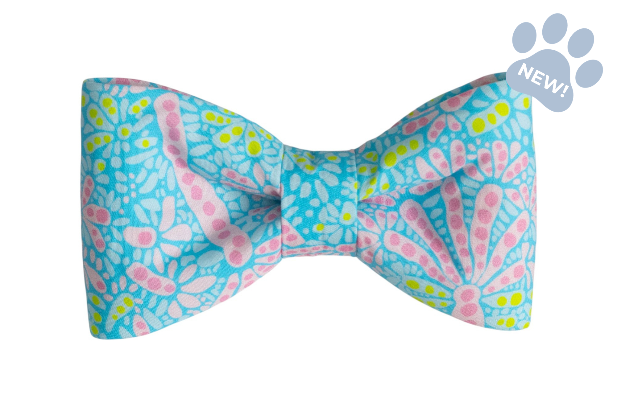 Bright blue patterned dog bow tie with stylized pink blossoms and green dots, shown flat against backdrop.