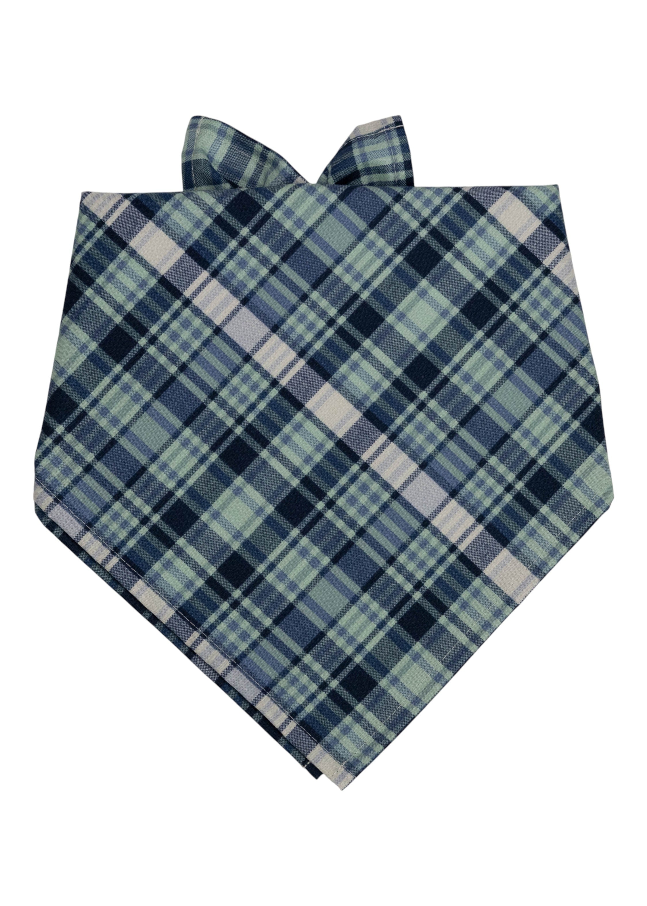 Dog bandana in a classic navy and light green plaid pattern, cut into a triangle and tied at the top for wearing around the neck.