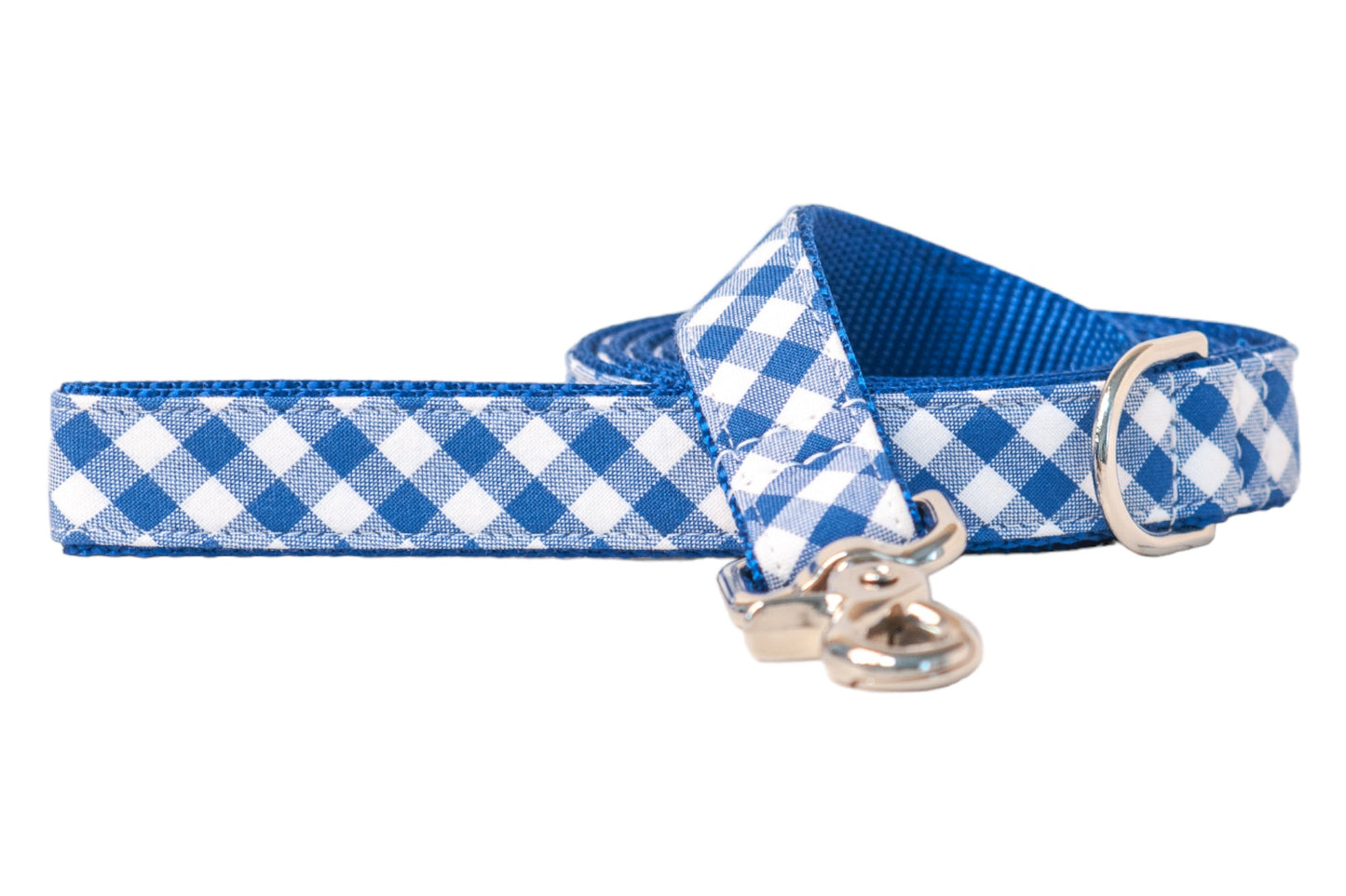 A dog leash with a classic blue and white picnic plaid checkered fabric exterior and a durable royal blue nylon backing. The leash features silver-tone hardware, including a swivel clasp and a D-ring near the handle. The fabric is tightly stitched for both style and strength.