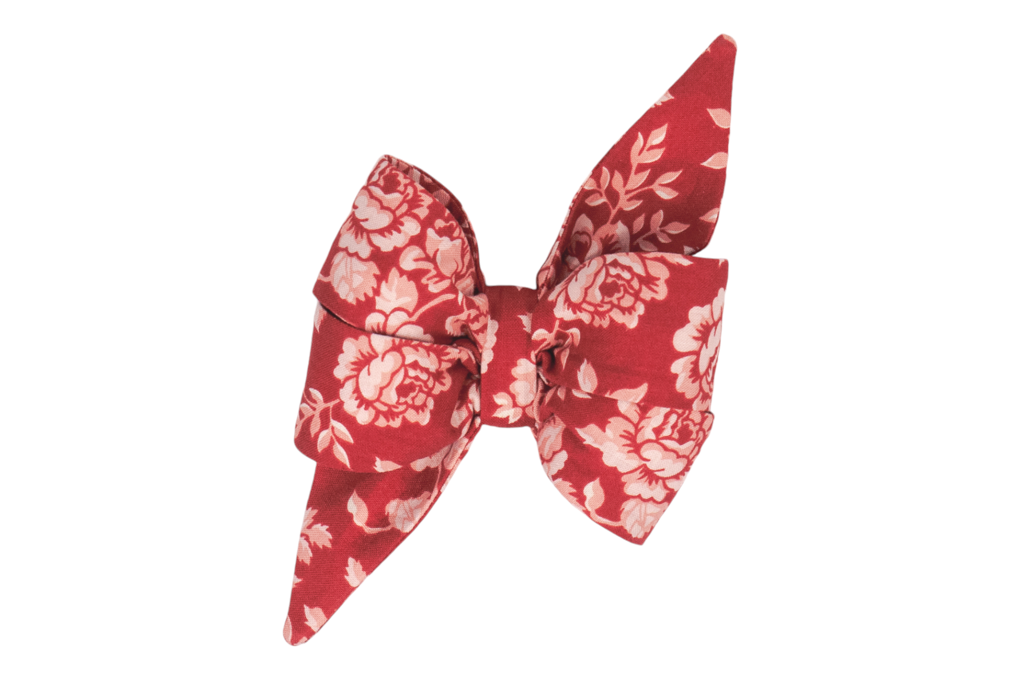 A handmade girl dog belle bow with an elegant red backdrop, beautifully decorated with vintage-inspired floral patterns in soft blush tones.
