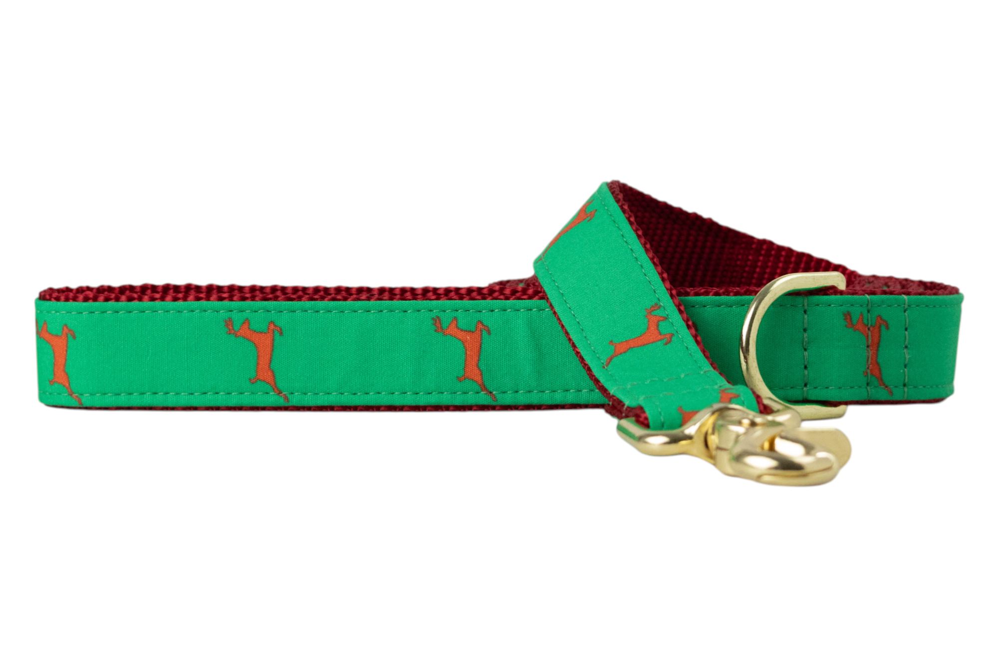 A green dog leash printed with reindeer silhouettes, featuring a nylon woven underside and luxe hardware including a swivel clasp and D-ring. 