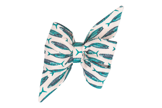 Girl dog belle bow with a nautical theme, featuring a pattern of turquoise and navy mackerel fish printed on an off-white background, offering a playful seaside look.