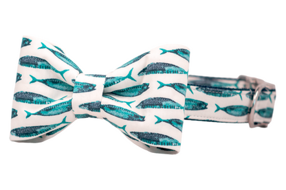  Nautical-themed dog bow tie and matching collar set with turquoise and navy mackerel fish prints on an off-white background, delivering a playful marine-inspired look.