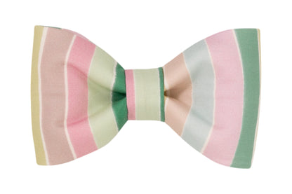 A dog bow tie with wide horizontal stripes in pastel tones of pink, green, cream, and tan, made from soft fabric with a symmetrical shape.