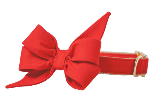 Stylish red dog collar adorned with a statement bow in matching fabric, crafted with dramatic folds and angular tips, paired with gold-tone hardware and beige interior webbing.