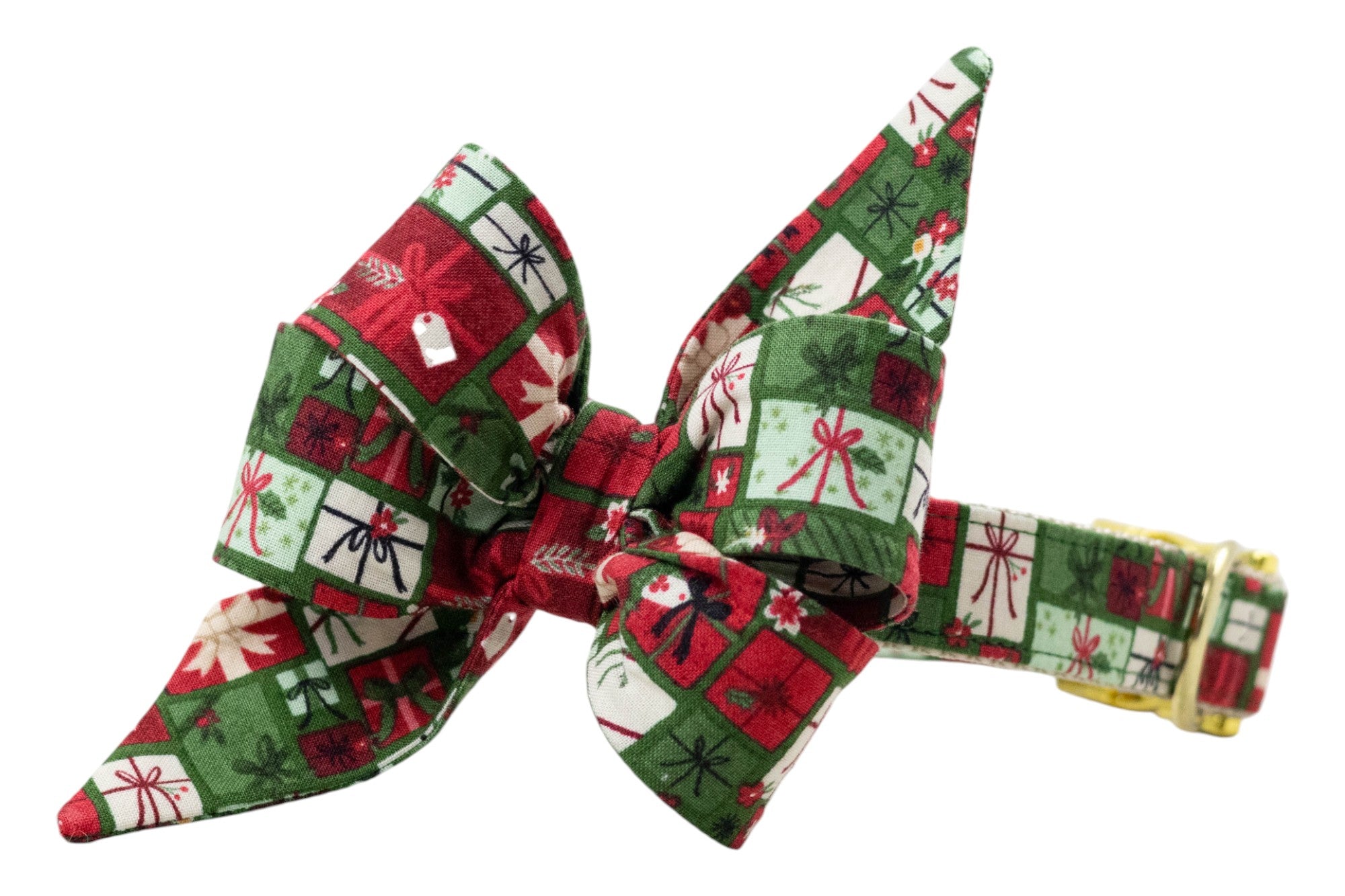 Oversized dog belle bow collar with festive gift box pattern, featuring bows, ribbons, holly, and tags. The belle bow has large pointed tails and is attached to a matching collar with polished hardware.