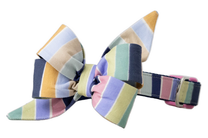 A colorful dog collar with a matching oversized belle bow in vertical pastel stripes. The structured belle bow has layered loops and pointed ends, while the collar features a D-ring and buckle for secure fastening.