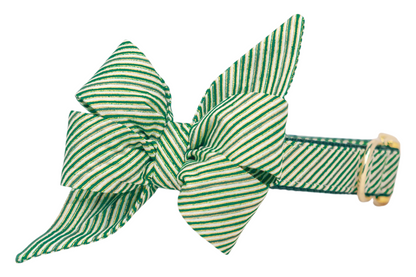 Holiday dog collar with an attached matching oversized belle bow, made from fabric featuring diagonal green stripes. The belle bow has exaggerated loops and extended pointed ends, giving the accessory a bold, eye-catching seasonal flair. The collar is finished with a polished buckle and D-ring.