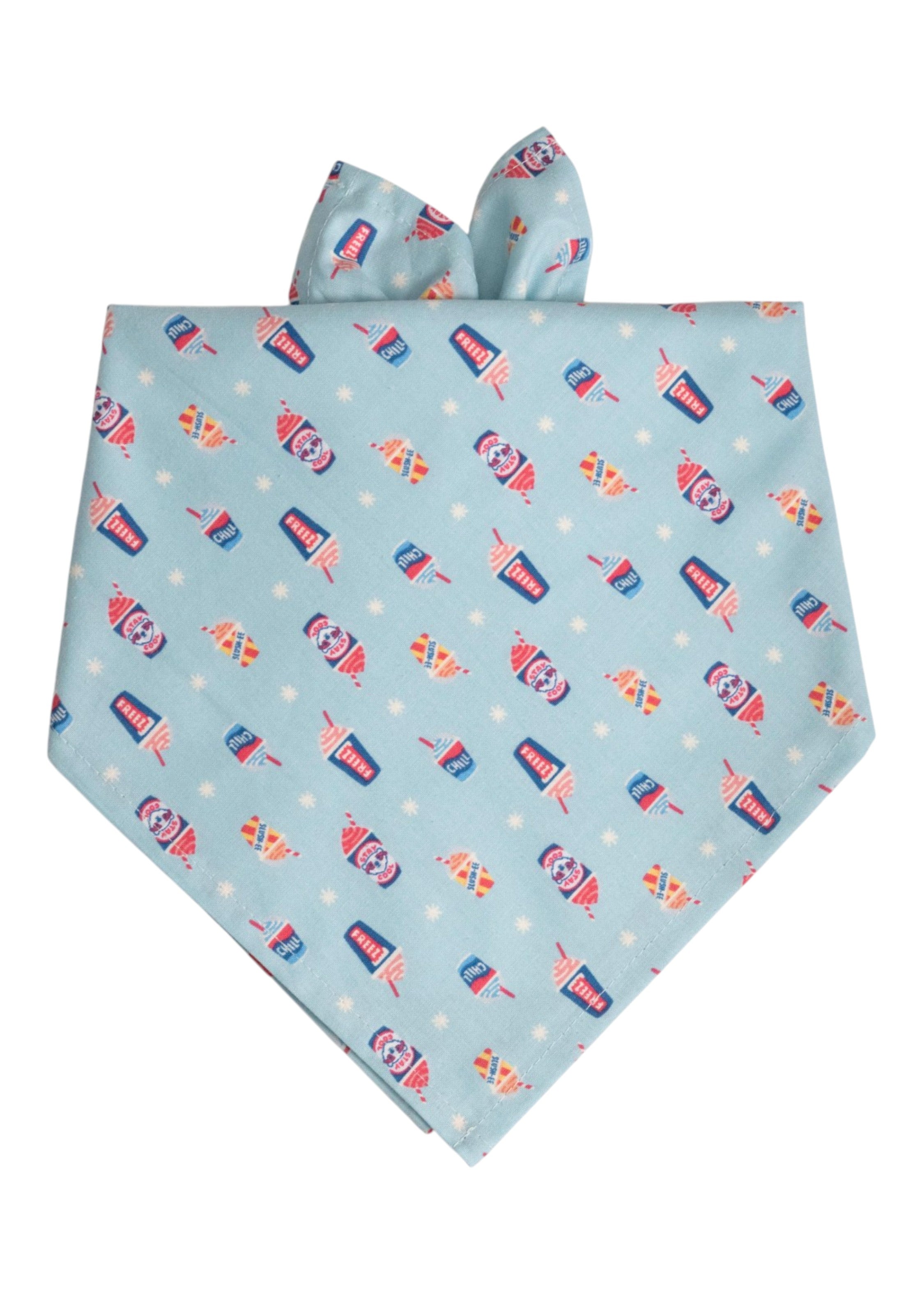 Light blue dog bandana with a playful pattern of colorful frozen drinks and small snowflakes, folded into a triangle with tie ends.