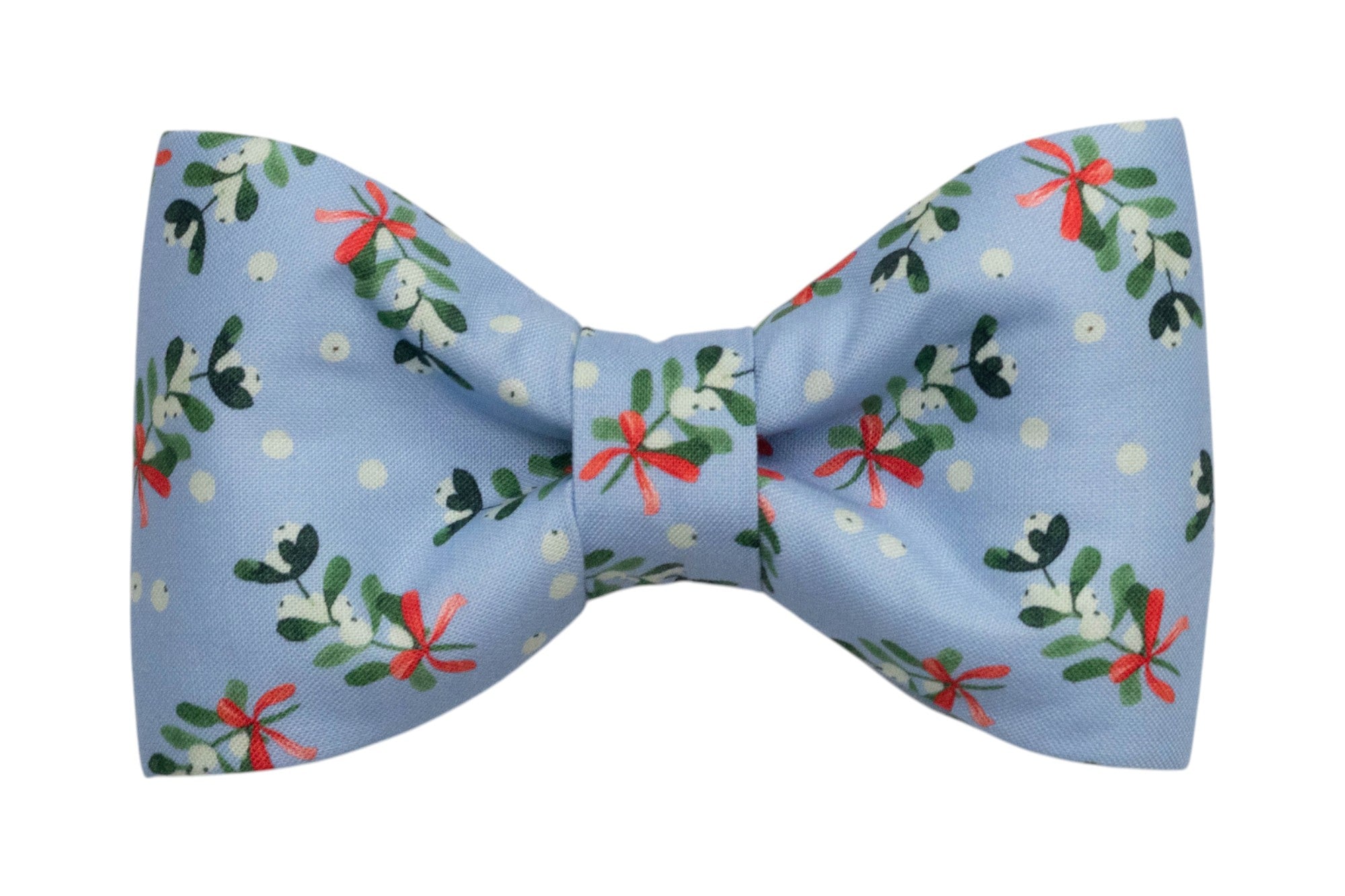 A festive dog bow tie made from light blue fabric decorated with mistletoe sprigs, berries, and small bows. The bow has a structured, symmetrical shape with a cinched center, creating a polished winter-themed accessory for dog collars.