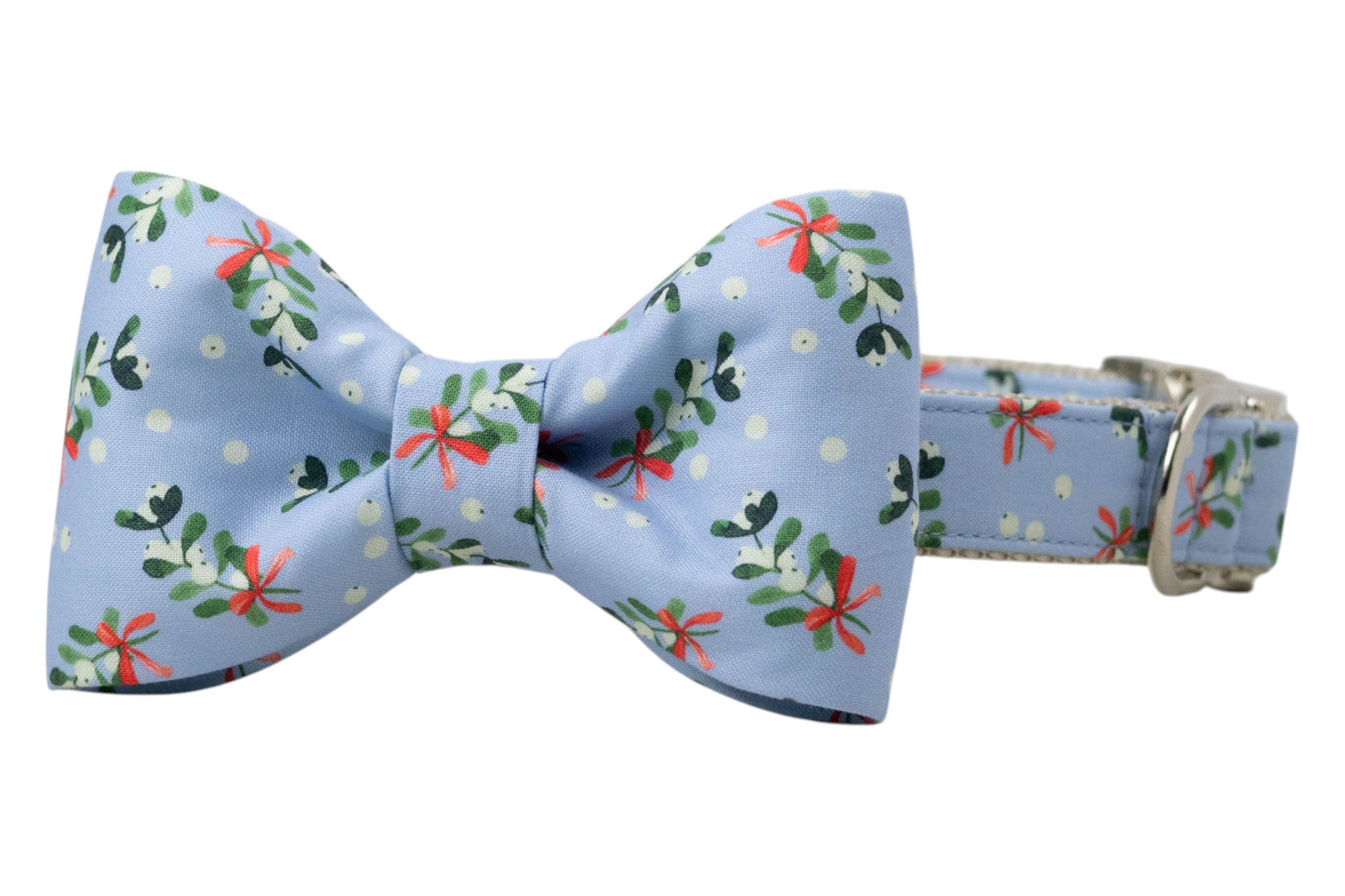 Holiday dog collar and bow tie set with a cheerful mistletoe print on soft blue fabric. The bow tie is centered on the collar and features the same festive foliage pattern. Finished with sleek hardware.