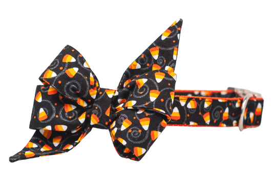 Dog collar with an extra-large belle bow in a festive print. The colorful print features candy corn with swirling accents, creating a festive and eye-catching Halloween look.