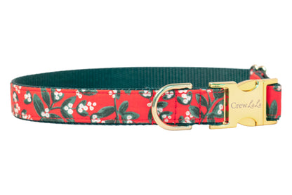 Red dog collar with a festive mistletoe print, featuring leaves and berries on a soft fabric exterior, dark woven interior, and polished buckle and D-ring—made for pups who love to sparkle through the season.