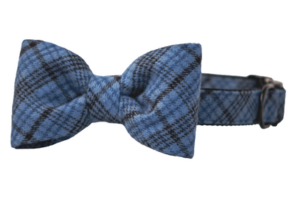 Blue plaid dog collar with a matching bow tie attached. The bow tie features a symmetrical, classic shape, and the collar includes a metal buckle and D-ring, giving it a polished and coordinated appearance.
