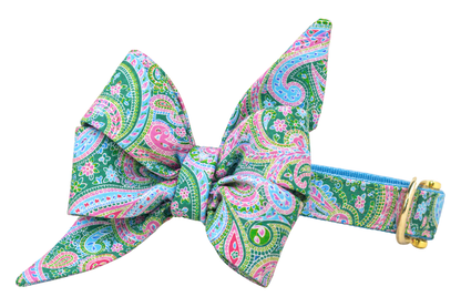 Dog collar featuring a large belle bow in Vera Paisley fabric, a green, sky blue, pink and lavender paisley print, attached to a matching Vera Paisley collar with a nylon inner lining and gleaming gold hardware, including a D-ring and buckle.