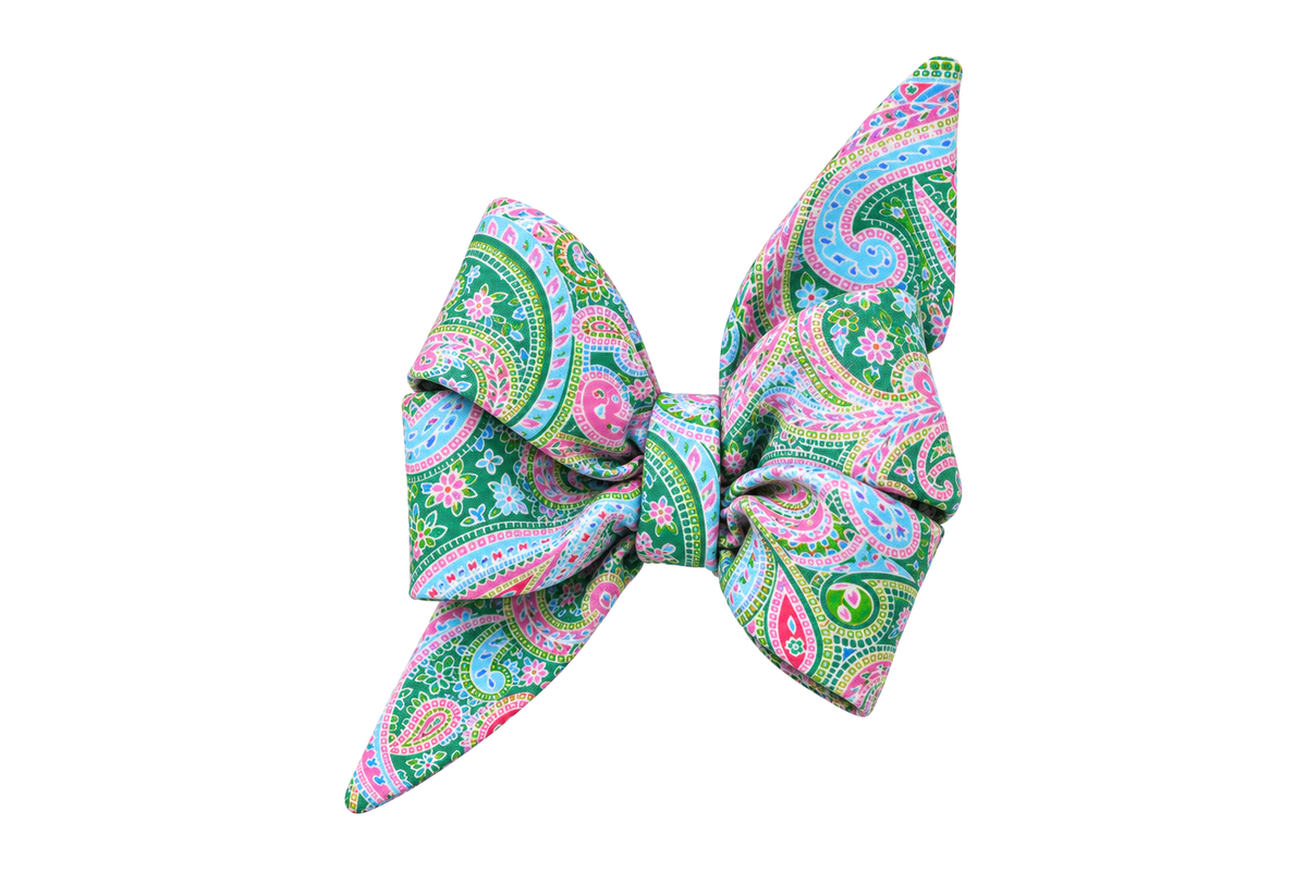 Standalone belle bow in Vera Paisley fabric, a green, sky blue, pink and lavender paisley print, with full upright loops and two pointed tails, photographed on a white studio background.