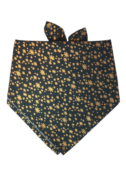 Dog bandana made of dark green fabric featuring an all-over metallic print of stars and starbursts in various sizes. The bandana is folded and tied at the top, combining a festive shimmer with a classic fold perfect for holiday celebrations or special events.