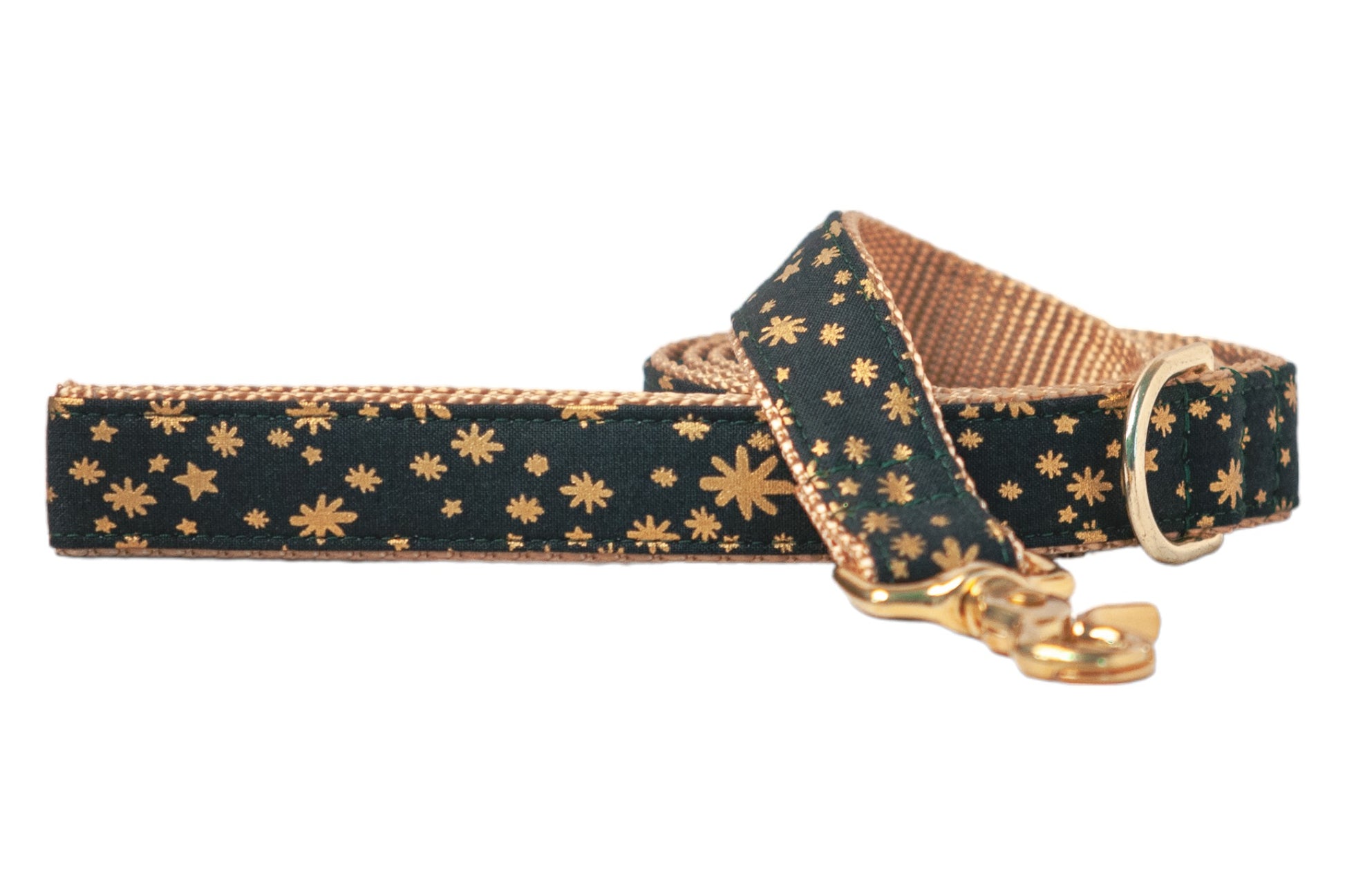 Stylish dog leash with a dark green outer layer decorated in a metallic starburst print. The pattern includes small scattered stars and larger bursts, giving the leash a shimmering holiday aesthetic. It’s finished with a sturdy woven underside and matching polished metal hardware.