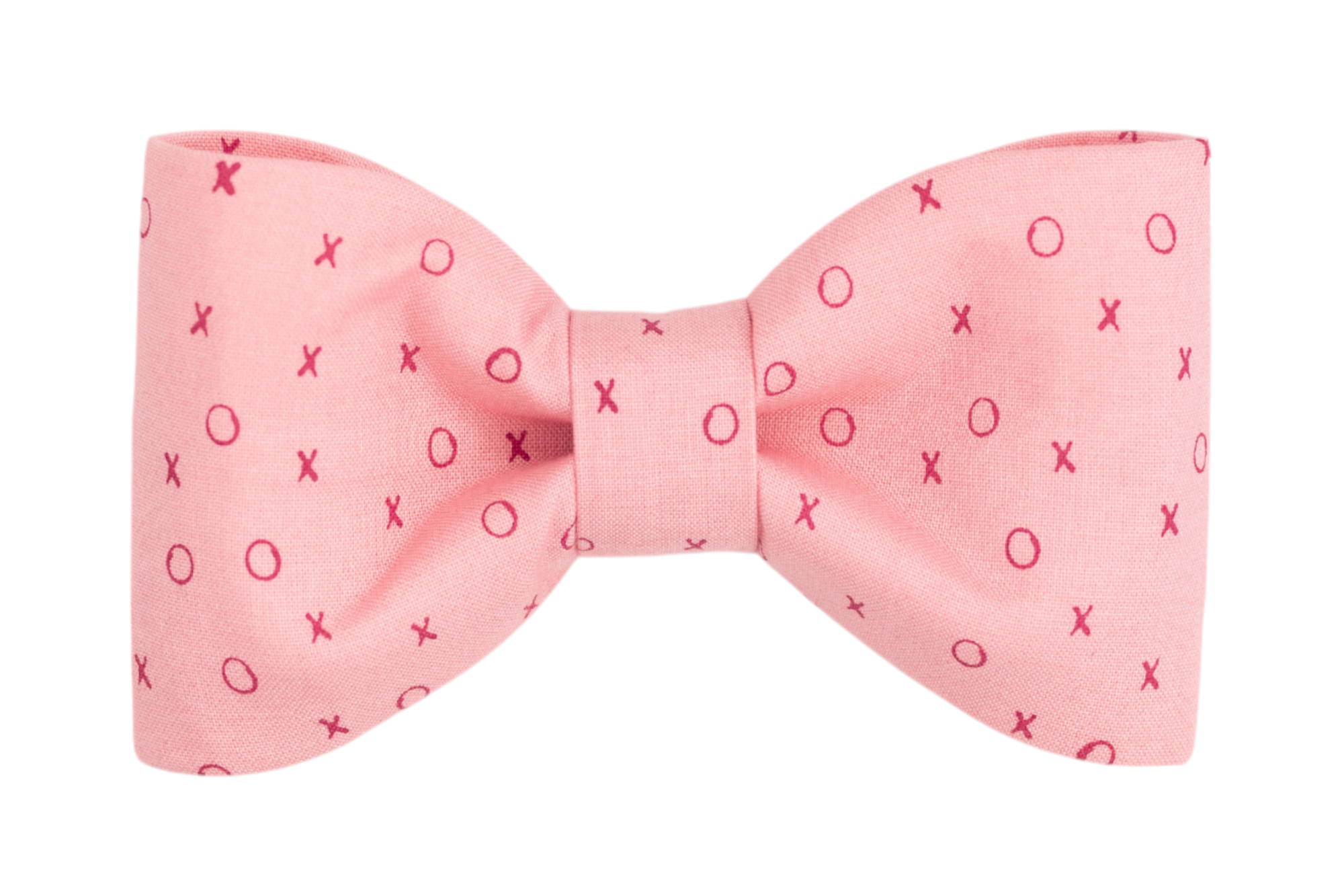 A handmade dog bow tie in a playful blush pink with a charming XO pattern in bright red, perfect for spreading love and cheer on Valentine's Day.