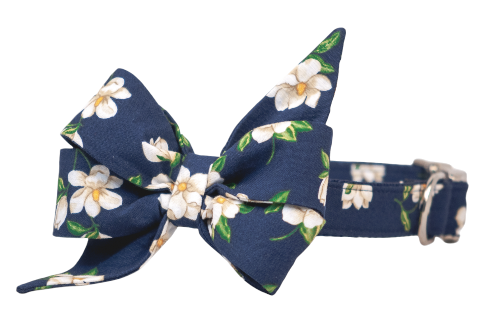 Navy blue dog collar adorned with an oversized fabric belle bow, both featuring an all-over print of white magnolia flowers with. The structured belle bow is double-layered for volume, creating an elegant and feminine silhouette. Silver-tone hardware adds a refined finish to the collar's adjustable strap.