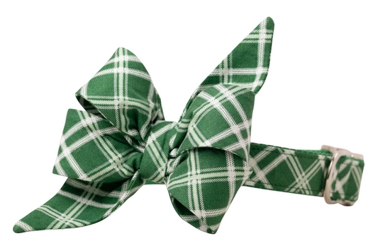 Green fabric dog belle bow with long pointed tails, decorated with a plaid pattern, styled in a layered double-loop design, and attached to a matching adjustable collar with metal hardware.