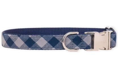 A stylish navy plaid dog collar with metal hardware and an engraved buckle, blending everyday durability with upscale charm for the pup who likes to strut in style.