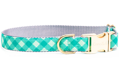 Dog collar in soft and vibrant greens plaid design, showing a checkered pattern with vertical pinstripes. The collar is finished with a metal D-ring and an engraved buckle.