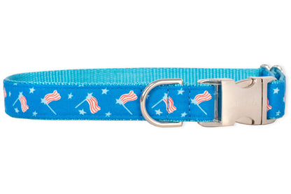 Patriotic dog collar with a vibrant blue strap covered in small American flags and stars, finished with polished silver-tone hardware and a sturdy side-release buckle.