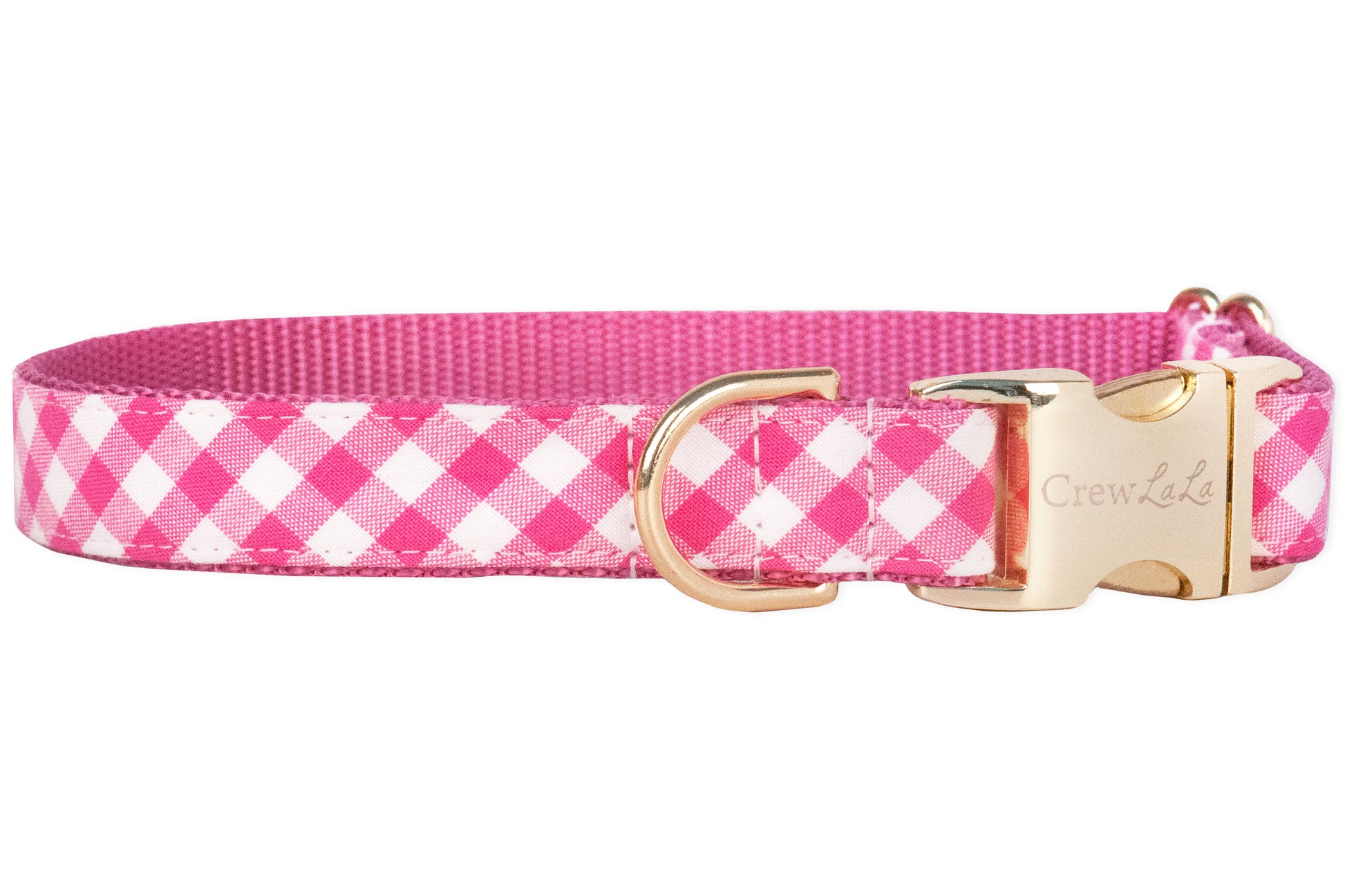Bright fuchsia and white plaid fabric dog collar backed by durable pink nylon webbing. Accented with gold-finish hardware including a branded buckle and secure leash ring.