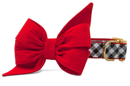 A festive belle bow dog collar featuring a bright red oversized bow with structured tails, paired with a classic black-and-white check collar and polished hardware. The perfect game day-ready look for your pups.