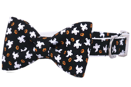Halloween dog collar with an attached matching bow tie, featuring a festive black fabric patterned with ghosts and jack-o’-lanterns. Complete with sturdy hardware, making it both spooky and stylish for seasonal wear.