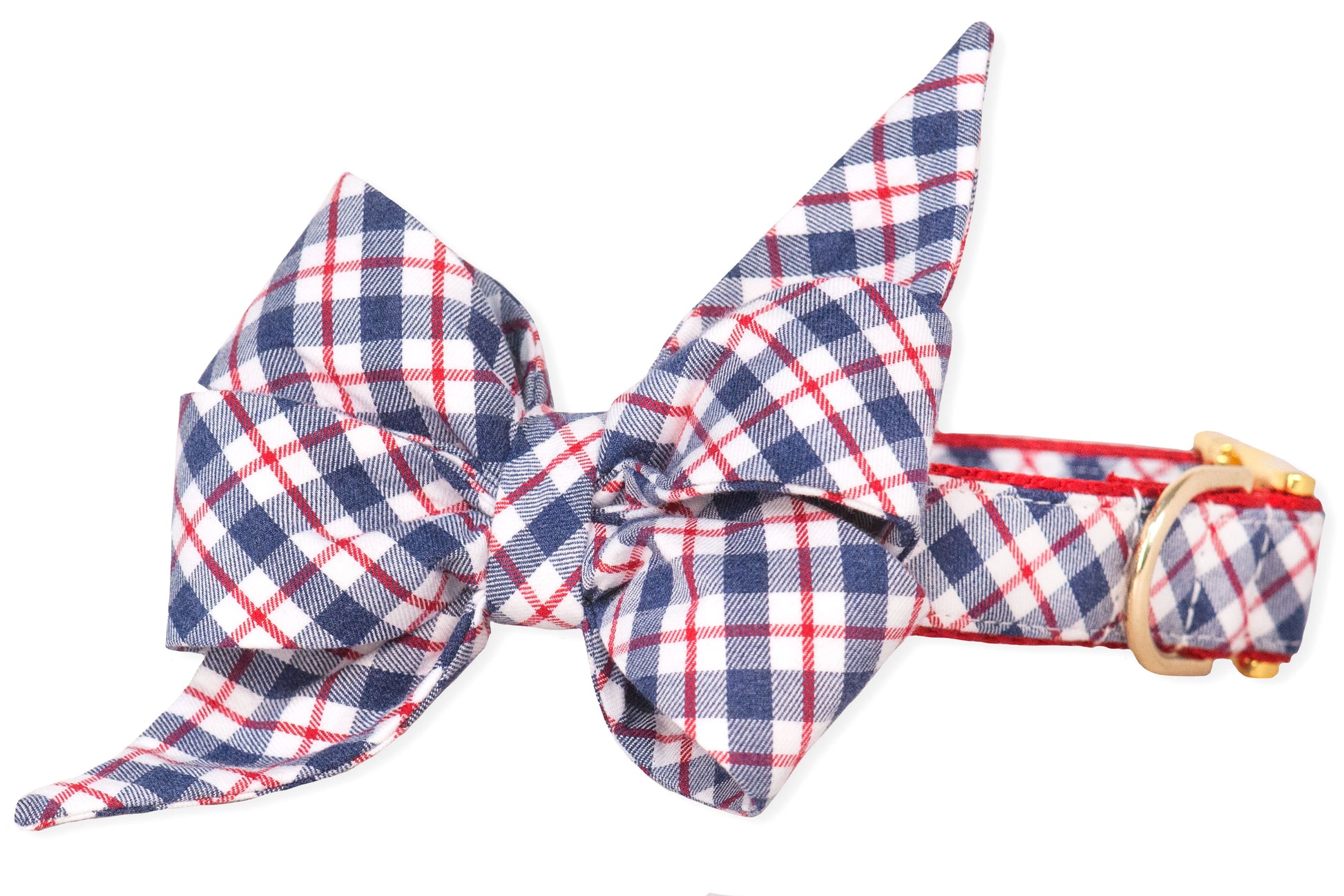 A decorative dog collar with a bold plaid bow tie in navy, red, and white. The feminine belle bow is voluminous and angular, adding a statement look to the matching collar, which is secured with a shiny gold-tone buckle.