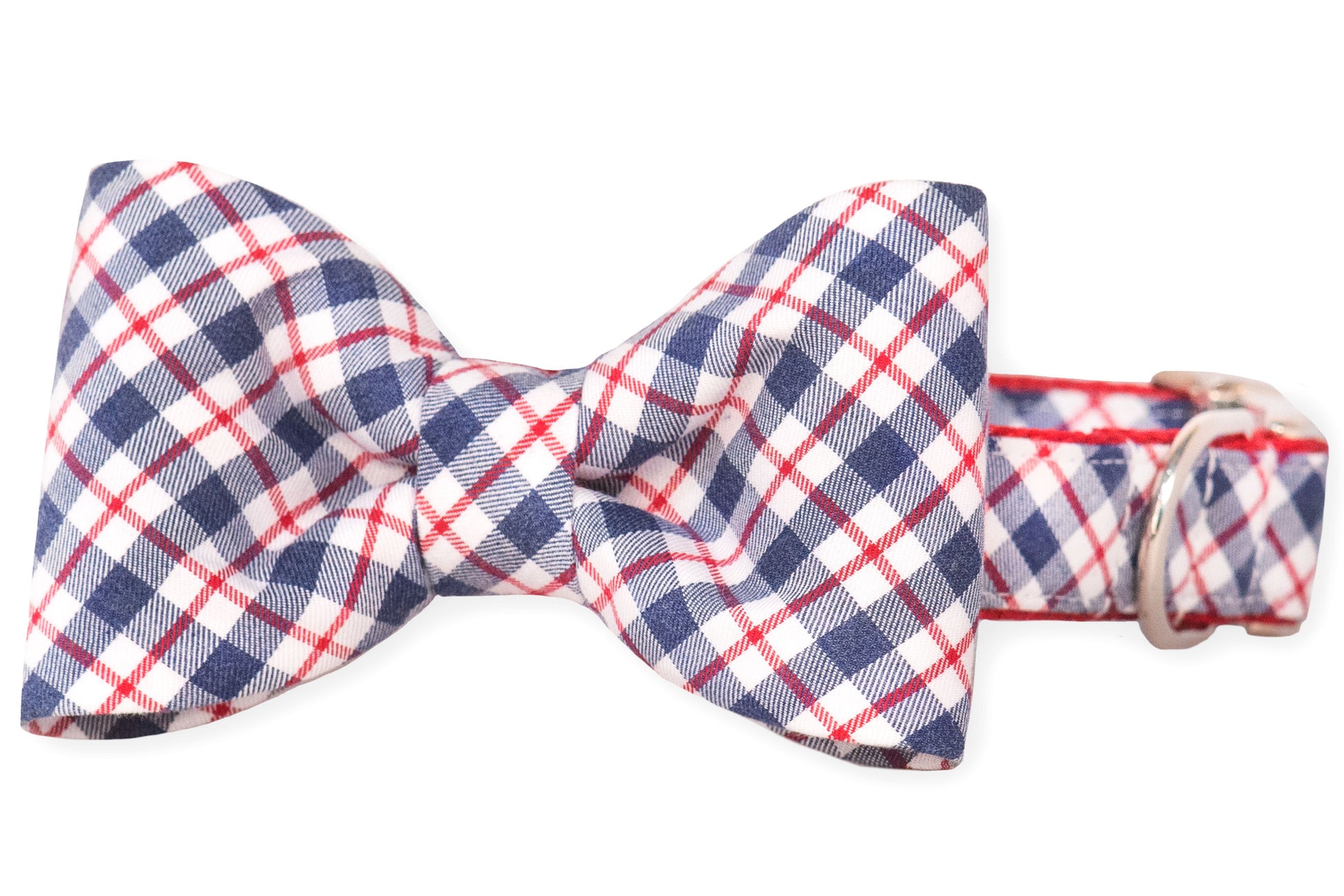 A stylish dog collar with a centered bow tie in a patriotic plaid pattern of navy blue, white, and red. The collar matches the bow’s fabric.