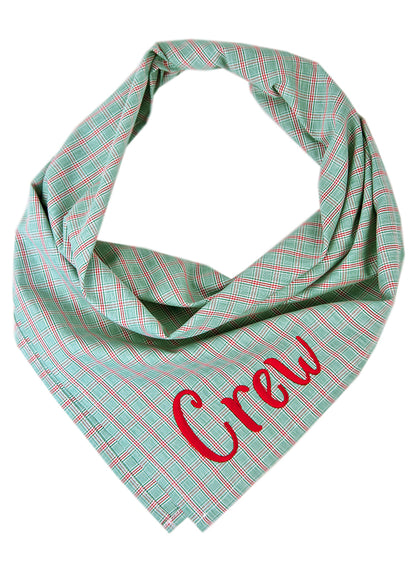 A crisp, cool plaid dog bandana in green—perfect for holiday photos, spring strolls, or just turning heads year-round. It has the name "Crew" embroidered on the bottom right.