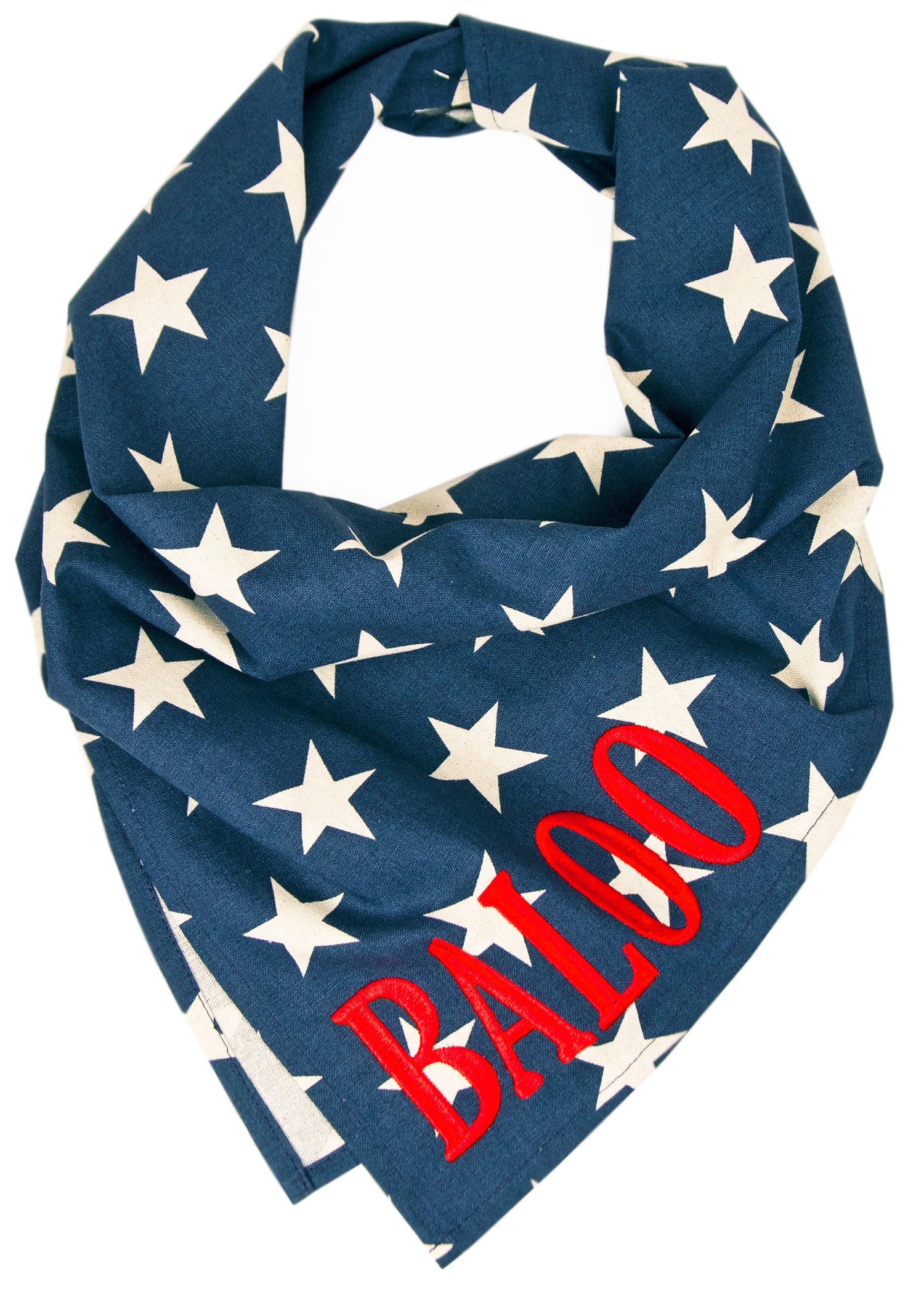 Personalized dog bandana featuring a dark blue background with scattered ivory stars and vivid red embroidered text reading “BALOO” on the lower corner. The bandana is styled in a folded triangle, perfect for festive or everyday wear.